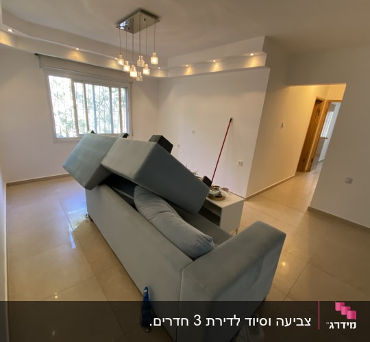 ספה הפוכה, מטאטא, קיר צבוע, חלון עם סורגים